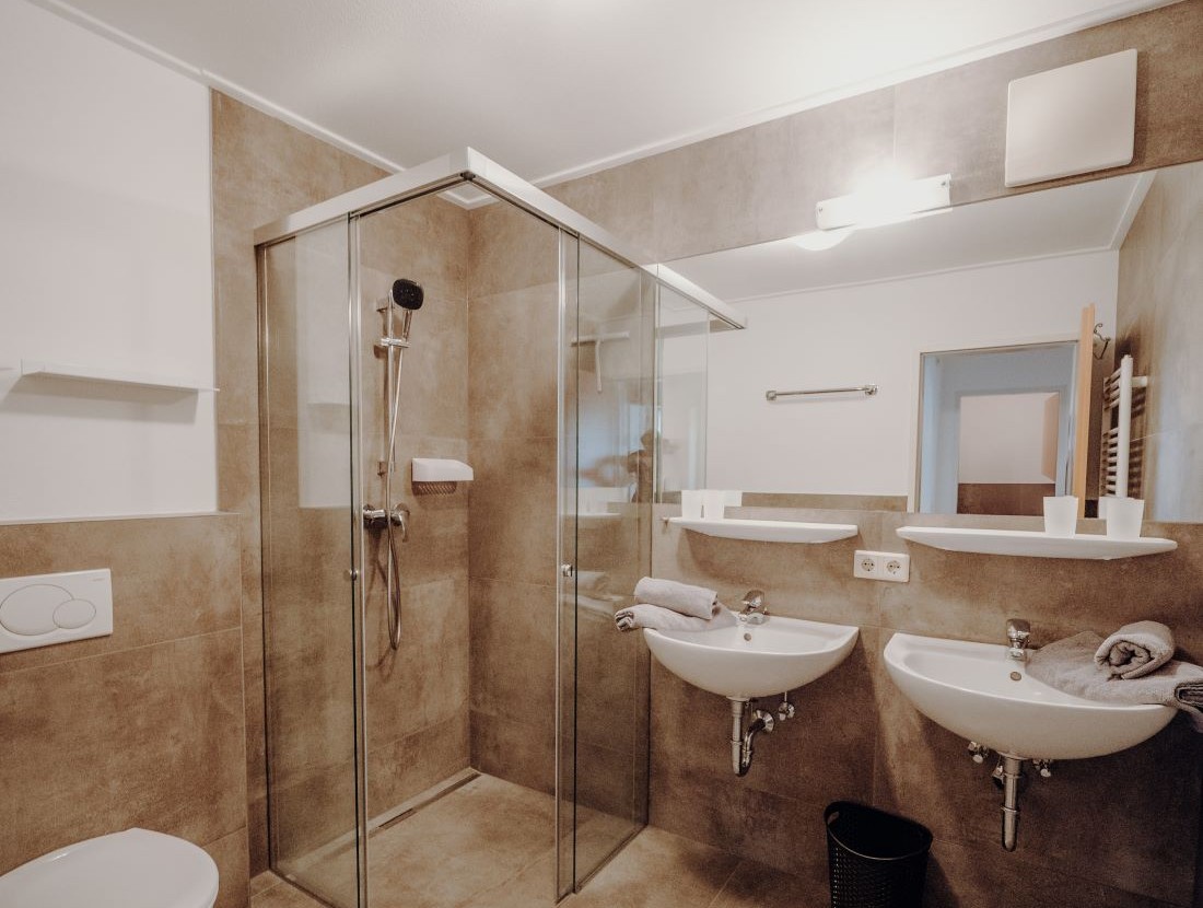 Badezimmer mit Dusche und Doppelwaschbecken