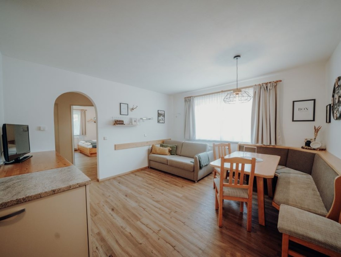 Geräumiges Wohnzimmer mit Flat-TV, Couch und Balkon