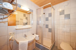 Modernes, helles Badezimmer mit Dusche, WC und Föhn
